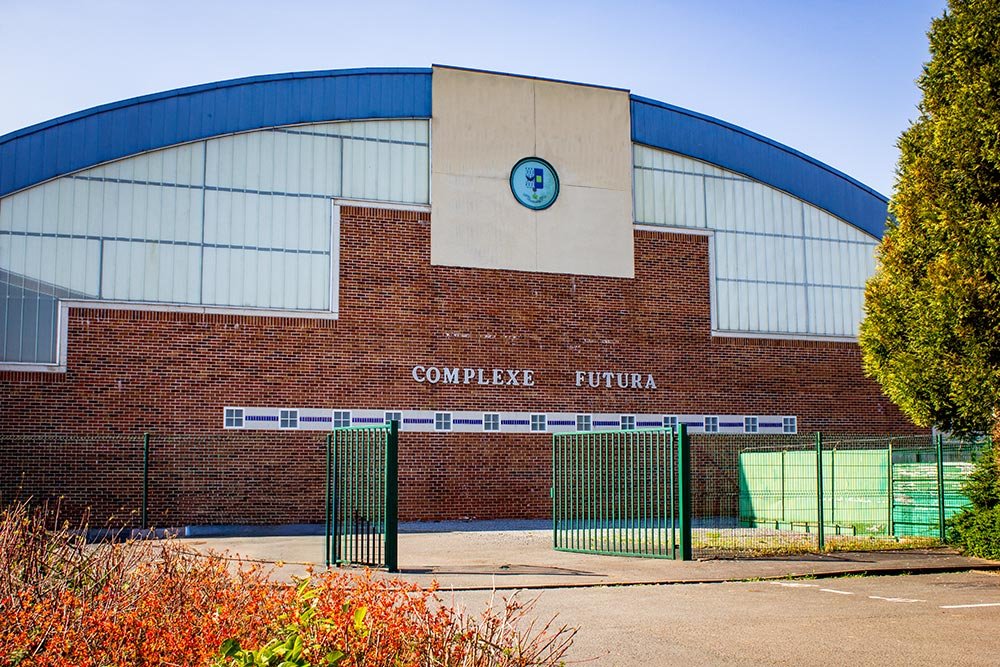 Façade en briques du complexe Futura, avec son toit arrondi bleu et l'inscription « Complexe Futura »